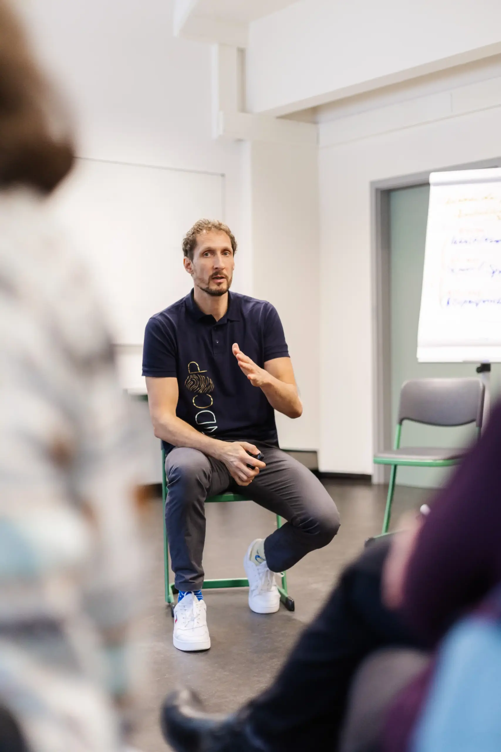 Marco Winzer im Schulungsraum auf einem Stuhl sitzend während eines Leadership Training