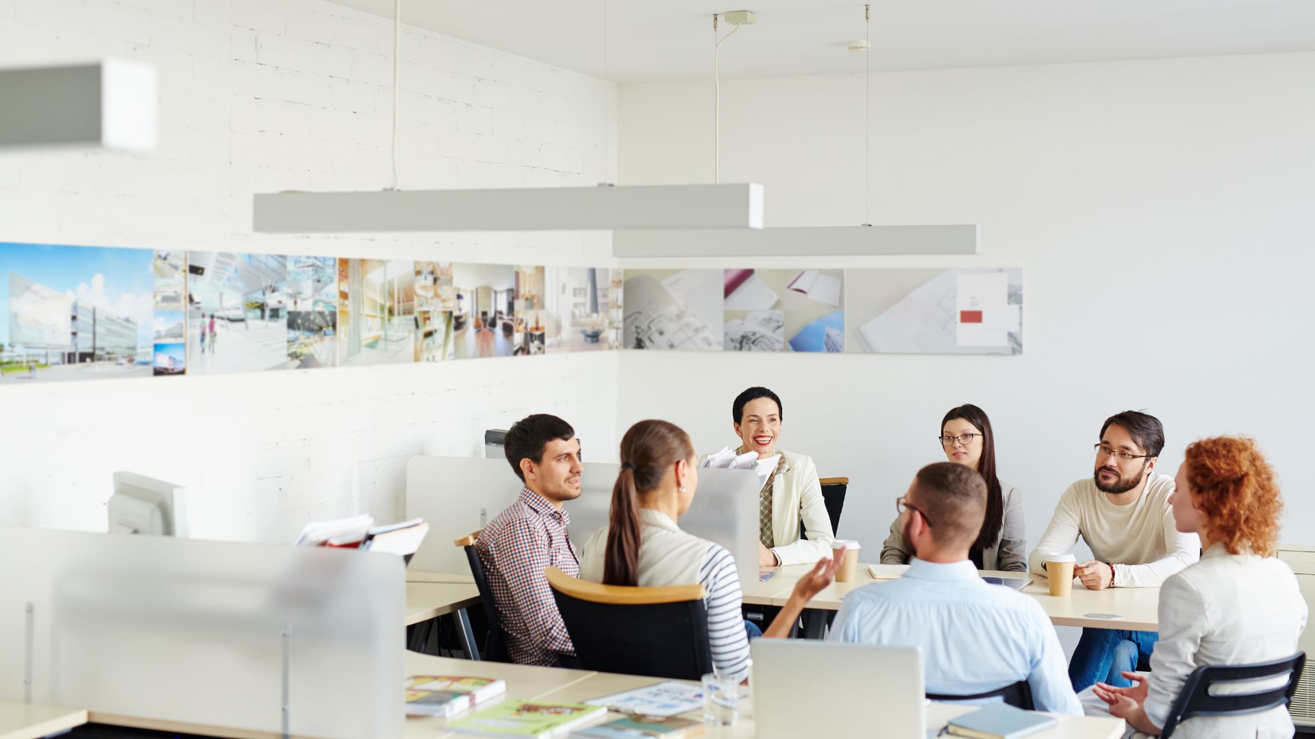 Psychologische Sicherheit schaffen: Teammitglieder, die im Büro zusammensitzen und miteinander sprechen